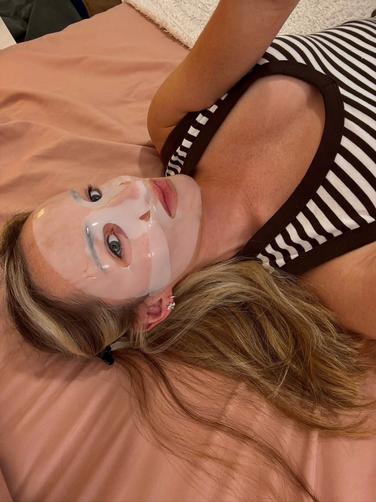 Léna allongée, masque en tissu sur le visage.