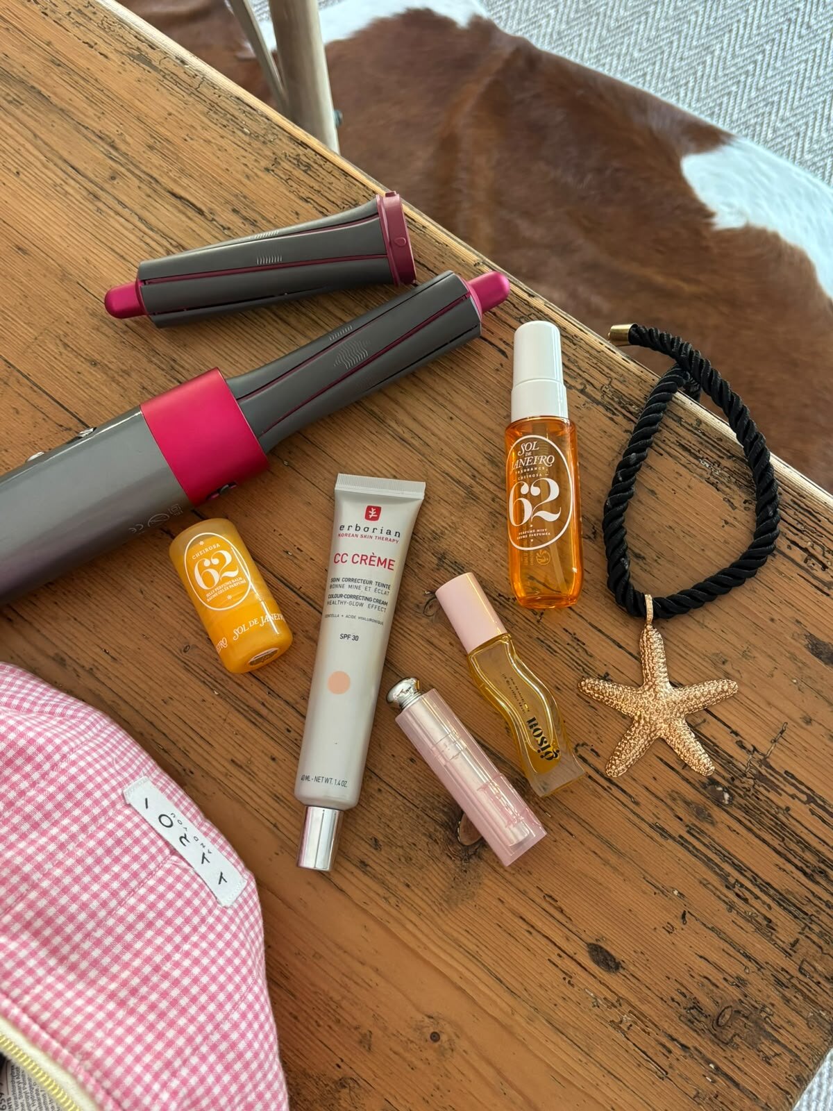 Composition de soins cheveux et maquillage sur une table en bois.
