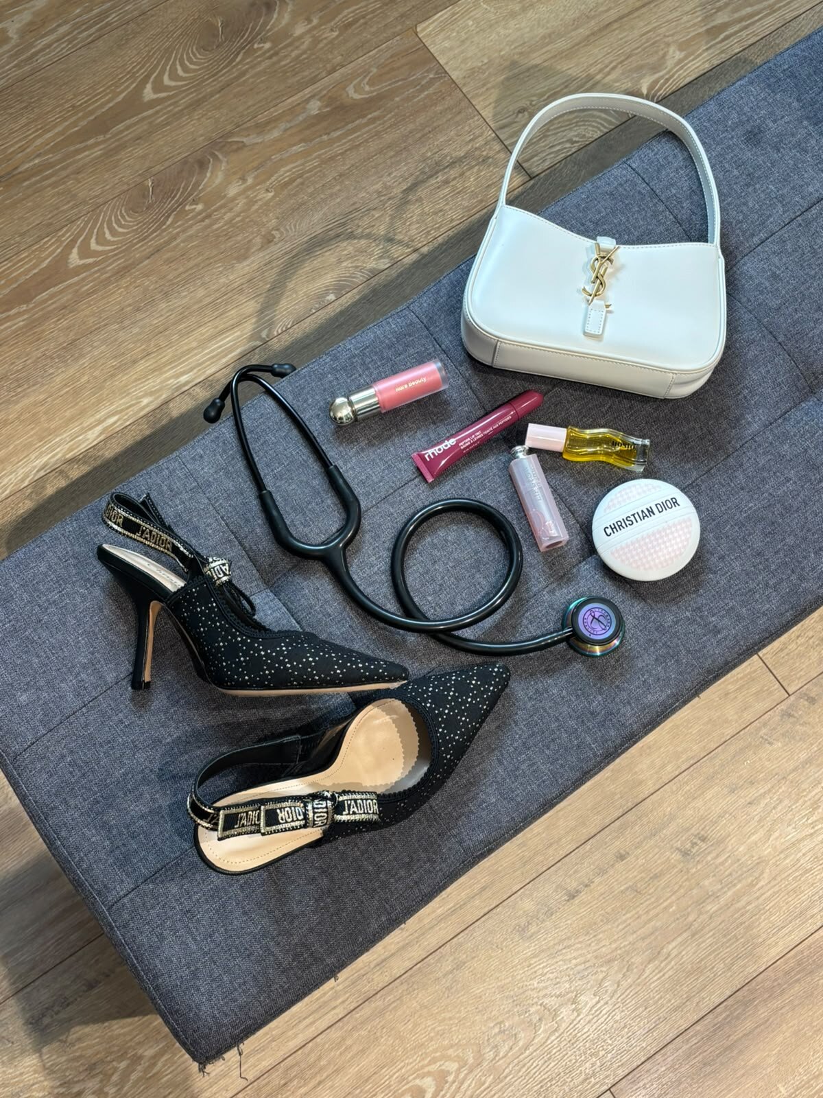 Composition mêlant stéthoscope, escarpins et accessoires de mode.