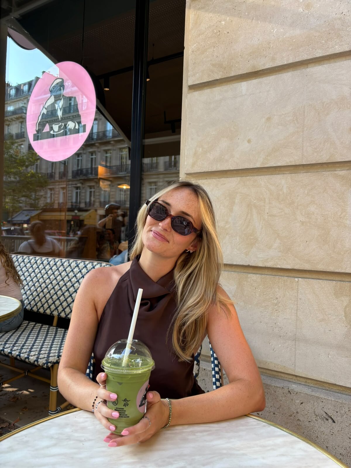 Léna en terrasse de café, un matcha glacé à la main.