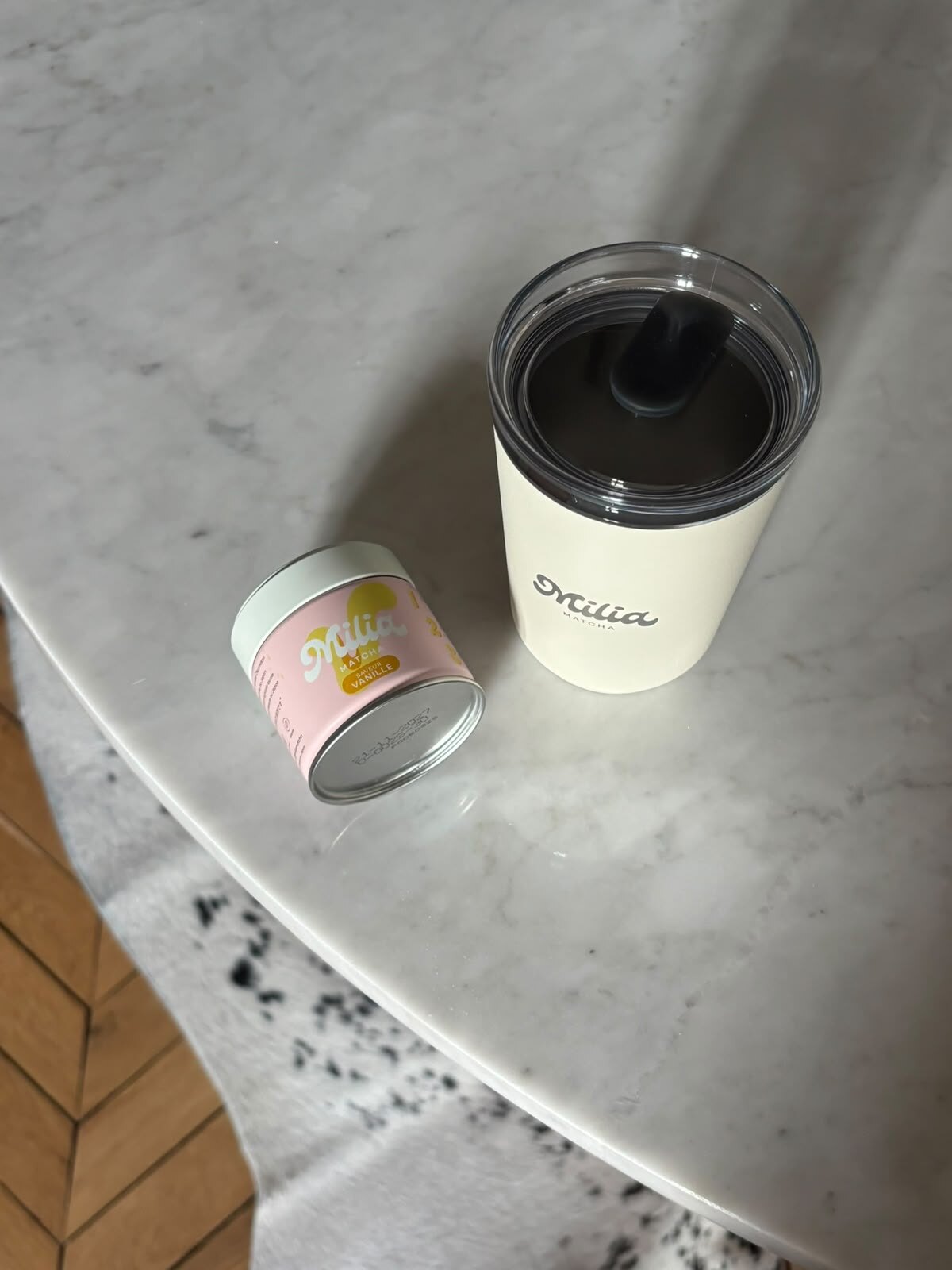 Gobelet de café et bougie posés sur une table en marbre.