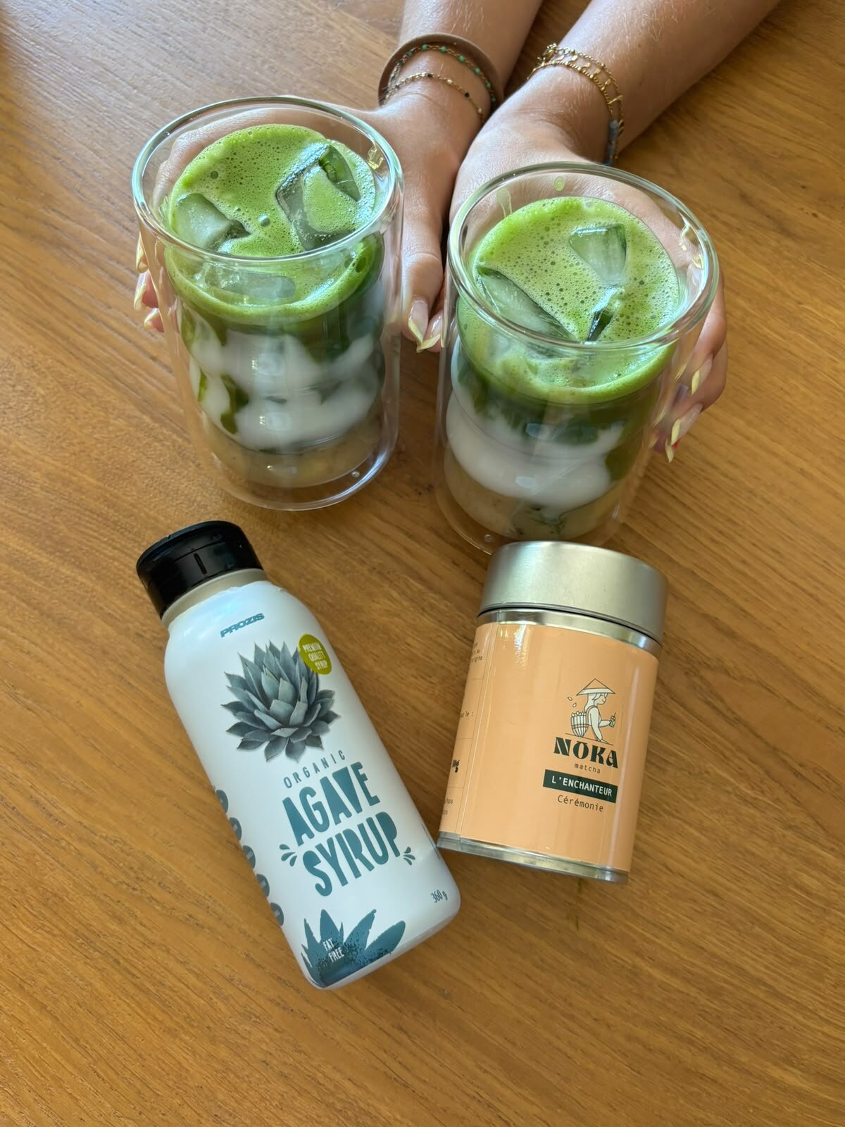 Deux matchas glacés à côté d’un sirop d’agave et d’un thé matcha.